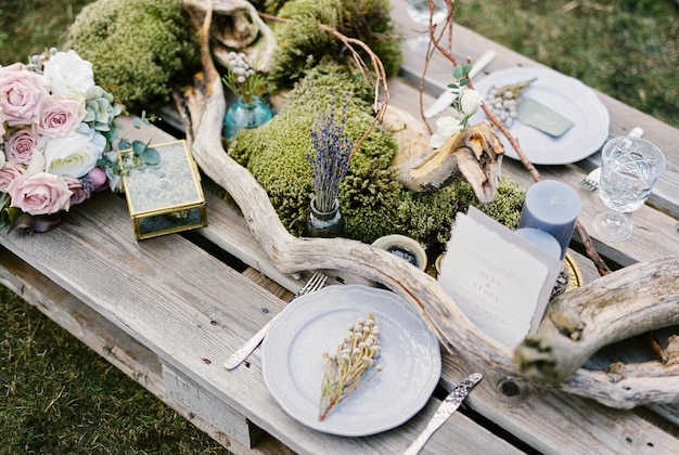 Ein Blumenstrauß liegt auf einem servierten Hochzeitstisch mit Kerzen und Einladungen