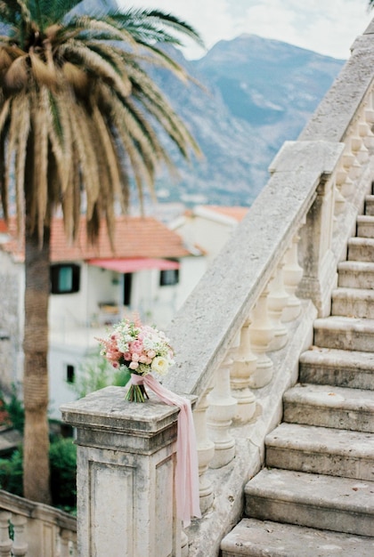 Ein Blumenstrauß steht auf einer Marmorbalustrade in der Nähe der Treppe