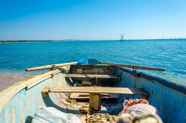 Ein Boot im Ozean mit einem blauen Himmel und einer weißen Wolke im Hintergrund.