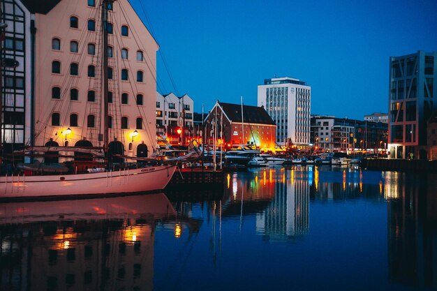 Ein Boot ist vor einem Gebäude mit einer Stadt im Hintergrund angedockt.