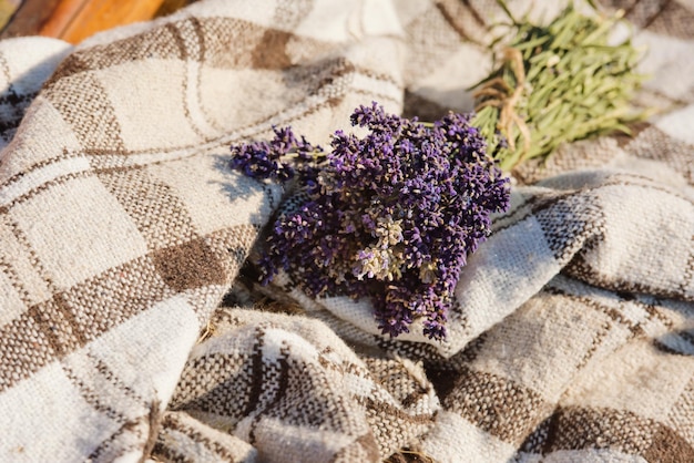 Ein Bouquet aus frischem Lavendel auf einer karierten Bettdecke