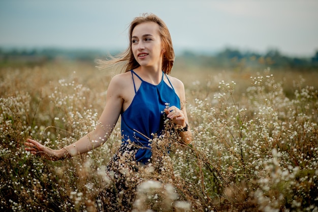 Ein brünettes Frauenmädchen mitten in einem blühenden Feld. Pollen- und Blütenallergie.