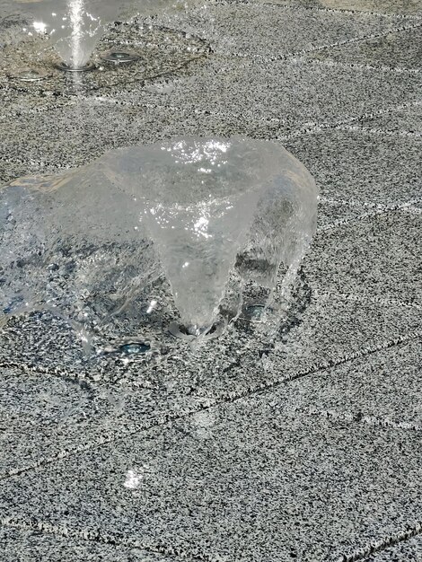 Ein Brunnen auf einer grauen Keramikfliese mit ausgeschaltetem Licht zur Beleuchtung