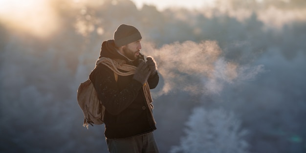 Ein brutaler Tourist geht im Morgengrauen durch den schneebedeckten Wald