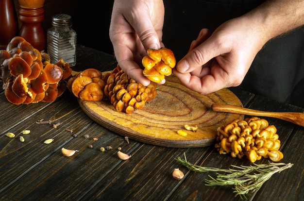 Ein Bündel frischer Waldpilze in den Händen eines Mannes, bevor sie sortiert und gekocht werden