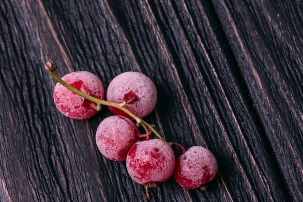 Ein Bündel gefrorene Johannisbeerbeeren auf einem Holztisch