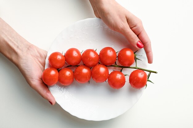 Ein Bündel roter Tomaten und Hände isoliert