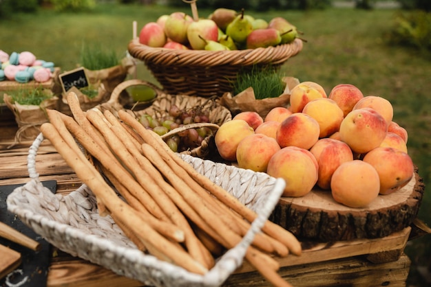 Ein Buffettisch mit verschiedenen Früchten wie einem Apfel und einer Birne mit italienischen Stäbchen