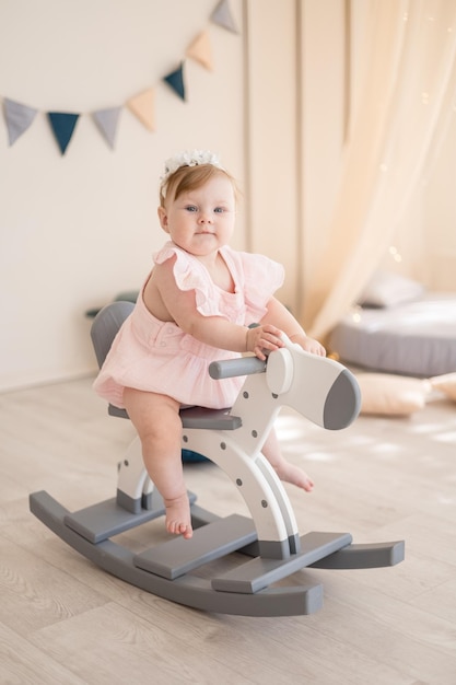 Ein charmantes kleines Mädchen spielt in einem gemütlichen, hellen Kinderzimmer mit Wigwam und Stofftieren Das Innere des Kinderzimmers Lustiges Baby im Kinderzimmer zu Hause