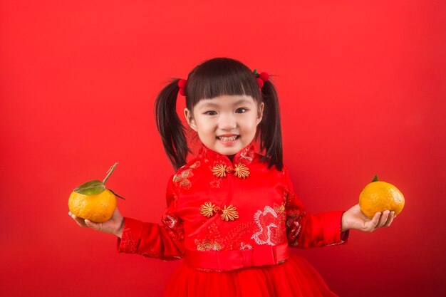 Ein chinesisches Mädchen, das Orangen für das Frühlingsfest hält