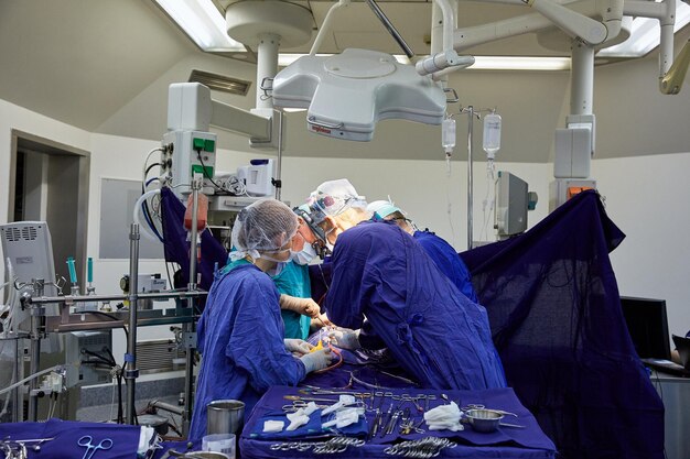 Ein Chirurg mit Assistenten führt eine Operation in einem modernen Krankenhaus durch. Medizinisches Team, das Operation durchführt.