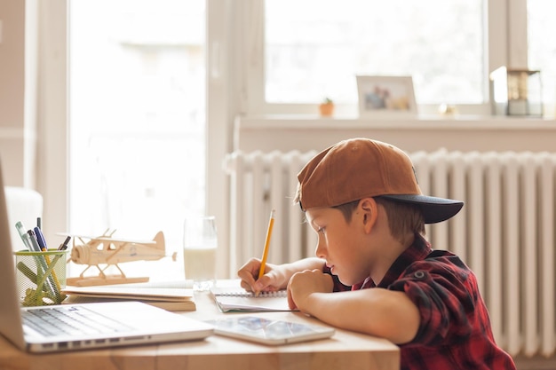 Foto ein cooler grundschüler macht seine hausaufgaben im wohnzimmer