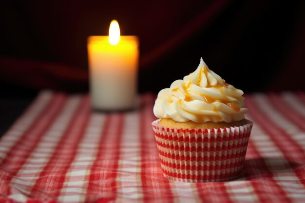 Ein Cupcake mit einer brennenden Kerze auf einer gemusterten Tischdecke