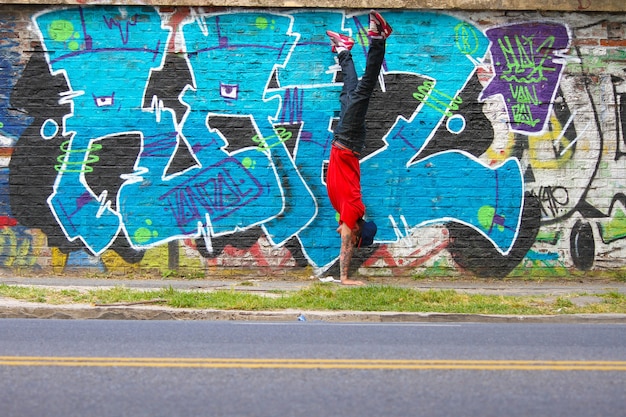 Ein darstellender HipHop-Tänzer vor einer Graffiti-Wand.