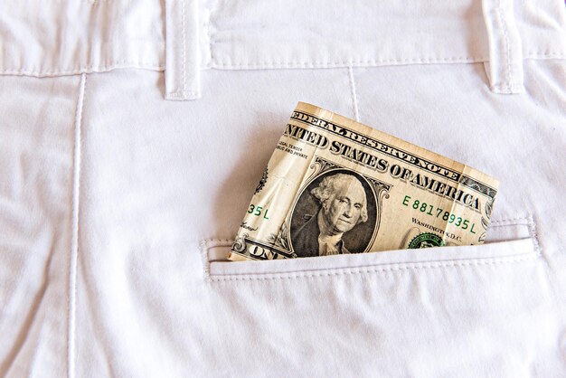 Ein-Dollar-Schein gefaltet in einer weißen Jeanstasche