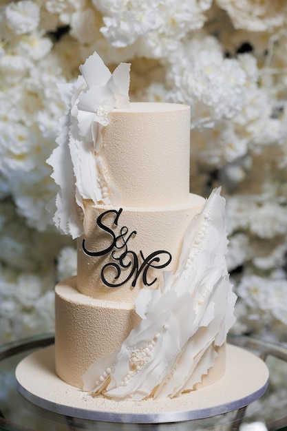 Ein dreistöckiger Hochzeitskuchen mit den Worten S M auf der obersten Stufe