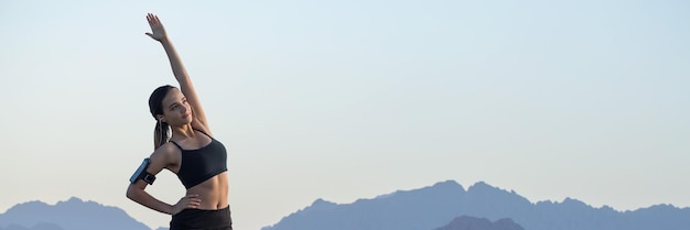 Ein dünnes, athletisches mädchen macht am frühen morgen zwischen den unterrichtsstunden vor dem hintergrund der berge eine pause und genießt stille und freiheit