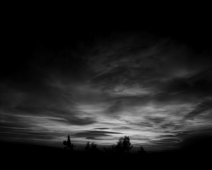 Foto ein dunkler himmel mit wolken und bäumen im vordergrund