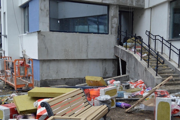 Ein Durcheinander auf einer Baustelle mit verstreuten Baumaterialien und Müll mit Dreckarmen