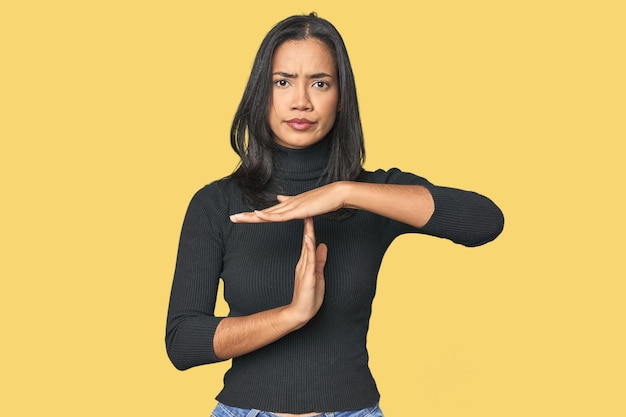 Ein einfaches Porträt einer jungen Latina, die eine Time-Out-Geste zeigt