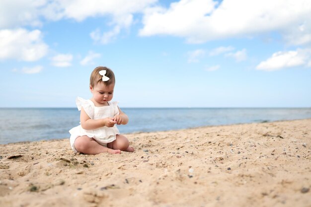 Ein einjähriges kaukasisches Baby am Sandstrand des Ostsees in Lettland