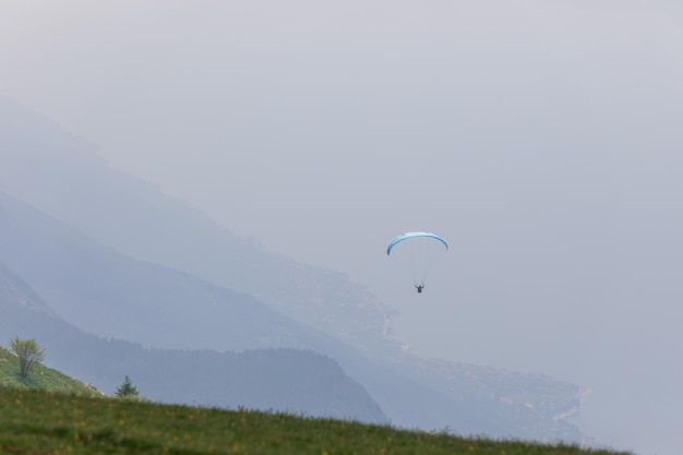 Ein einsamer Gleitschirm schwebt im Sommerdunst hoch am Gardasee Malcesine Verona Italien