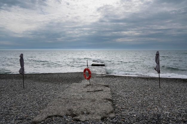 Ein einsamer Strand an der Küste von Sotschi und ein Rettungsring am Pier Adler Region Krasnodar Russland