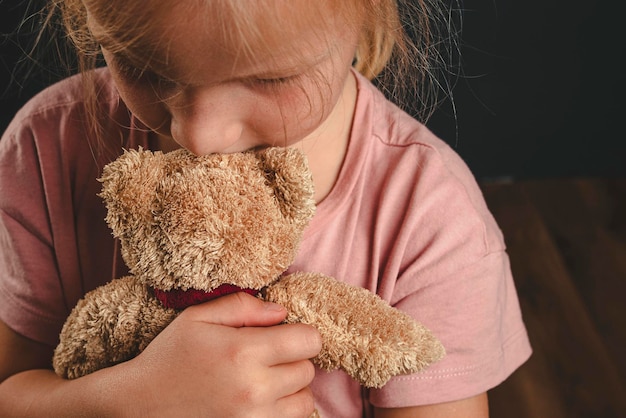 Ein einsames Mädchen umarmt einen Teddybärenstreit in der Familie, das Kind hat Angst vor der Scheidung der Eltern