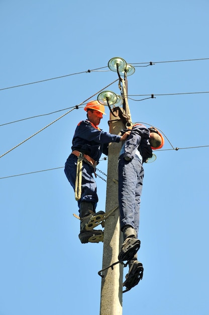 Ein Elektriker hilft dem von einem Stromschlag betroffenen Arbeiter. Training an einer Schaufensterpuppe.