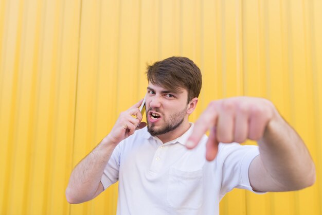 Ein emotionaler Mann ruft wütend am Telefon an