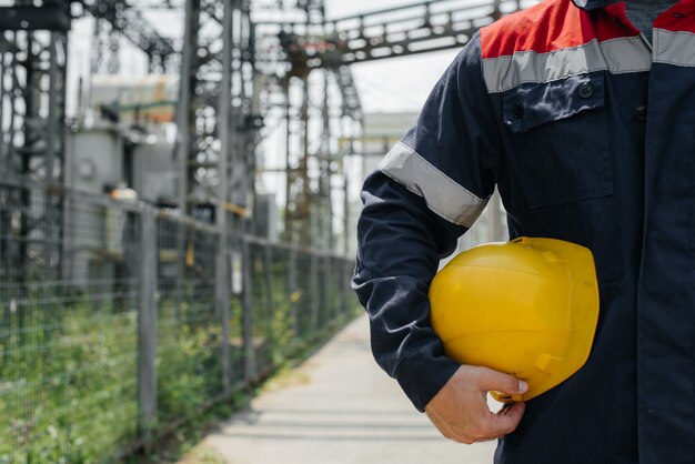 Ein Energietechniker mit einem Schutzhelm in der Hand