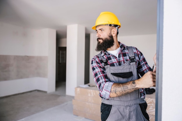 Ein engagierter Arbeiter, der im Bauprozess Materialberechnungen für die Wohnung durchführt