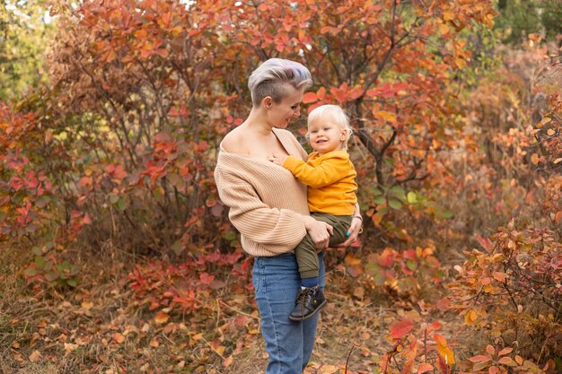 Ein entzückender kleiner Junge mit seiner Mutter im Herbstpark