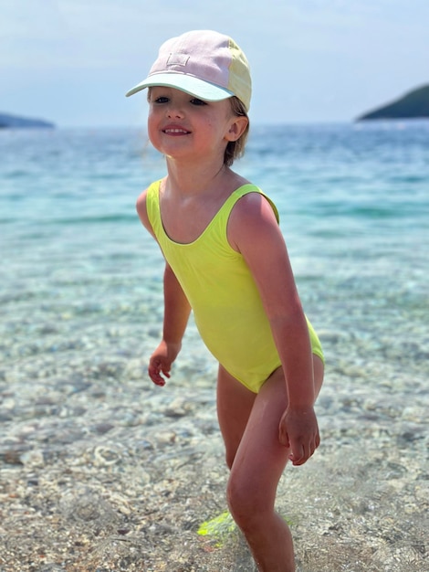 Ein entzückendes kleines Mädchen im Sommerferien am Strand