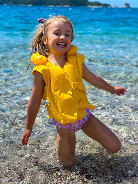 Ein entzückendes kleines Mädchen im Sommerferien am Strand