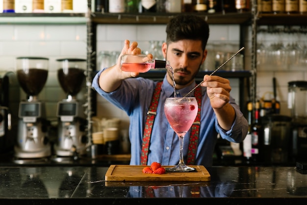 Ein erfahrener Barmann macht einen Cocktail im Nachtclub.