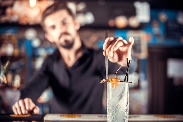 Ein erfahrener Tapster gibt einem Drink an der Bar den letzten Schliff