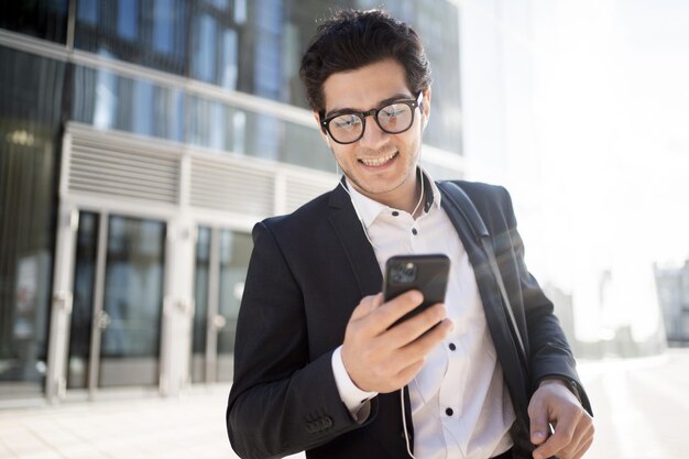 Ein erfolgreicher Geschäftsmann benutzt ein Telefon, geht ins Büro und trägt einen Business-Anzug