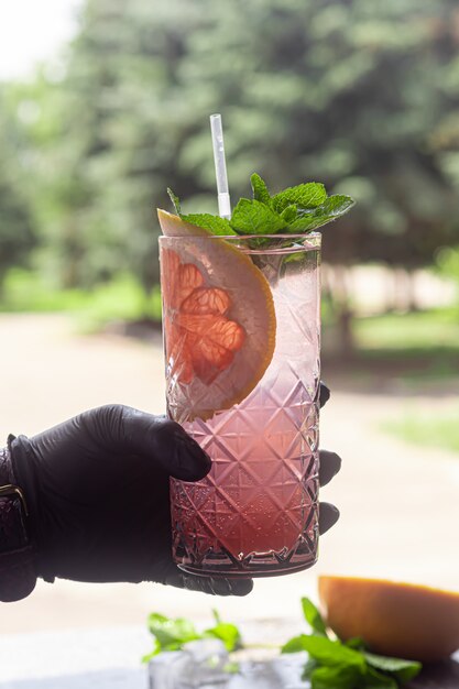 Ein erfrischender Sommercocktail mit einer Scheibe Grapefruit. Alkoholisches Getränk Paloma. Mit einem Zweig Minze und Eiswürfeln dekoriert.