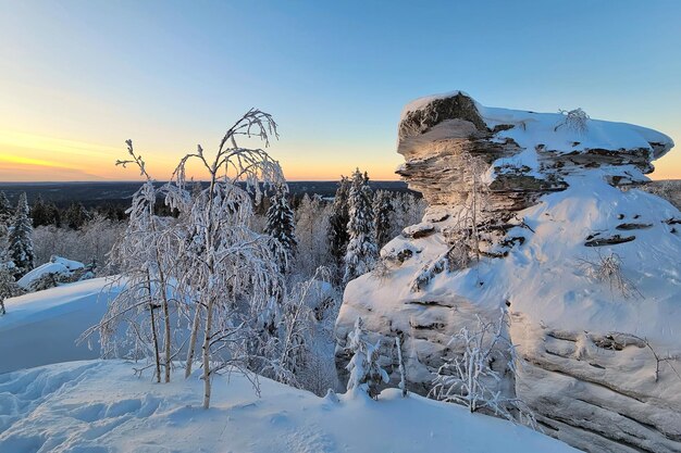 Ein erstaunlicher schneebedeckter Steinfelsen beim Sonnenuntergang