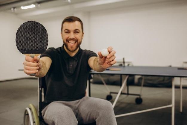 Ein erwachsener behinderter Mann im Rollstuhl spielt Tischtennis Eine Partie Tischtennis