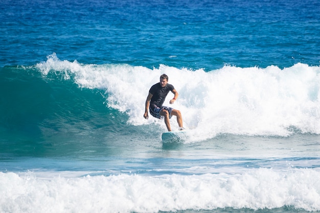 Ein Erwachsener reitet eine Welle auf einem Surfbrett. Surfen.