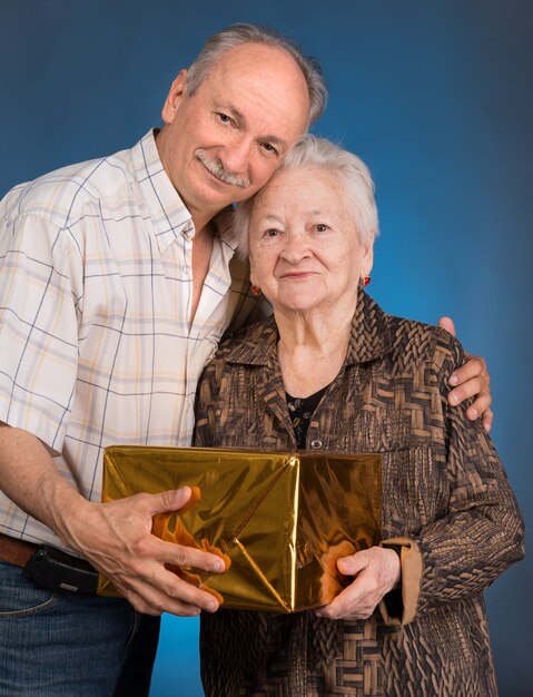 Ein erwachsener Sohn und eine alternde Mutter mit Geschenkbox