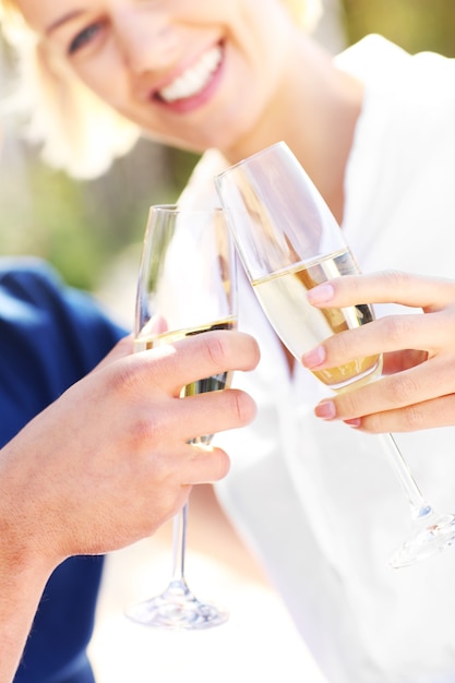 ein erwachsenes paar mit gläsern champagner am strand