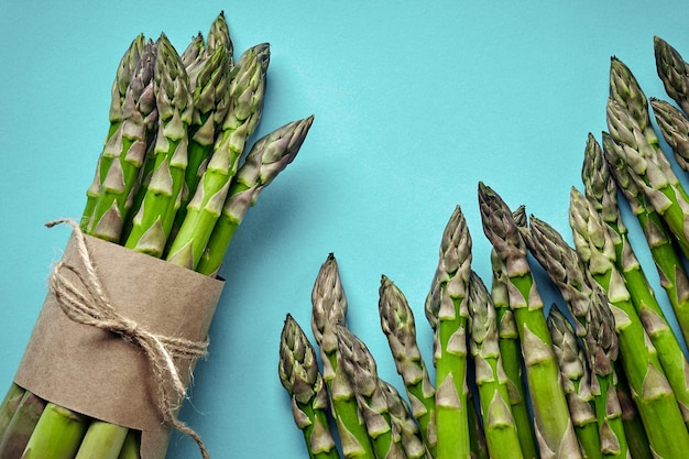 Ein essbarer roher Spargel auf blauem Hintergrund