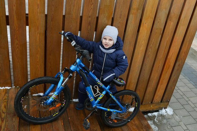 Ein europäischer Junge in Winterkleidung fuhr mit seinem Fahrrad nach draußen