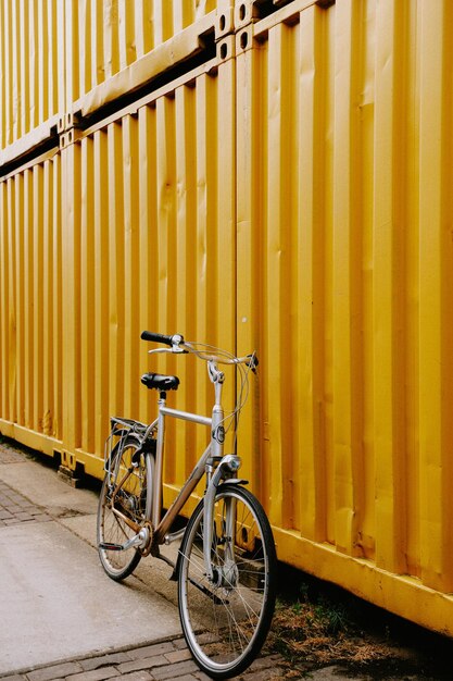 Foto ein fahrrad, das gegen eine gelbe wand geparkt ist