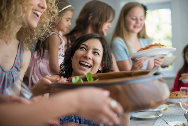 Ein Familientreffen für eine Mahlzeit Erwachsene und Kinder um einen Tisch