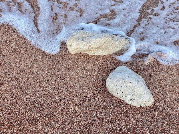 Ein Felsen am Strand ist von Wasser umgeben.