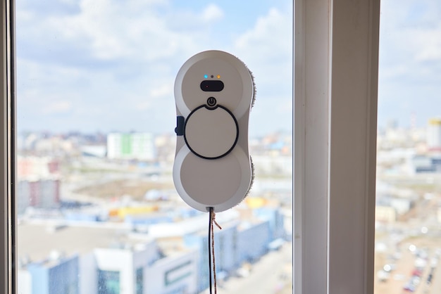 Ein Fensterputzroboter wäscht Glas vor der Kulisse von Hochhäusern